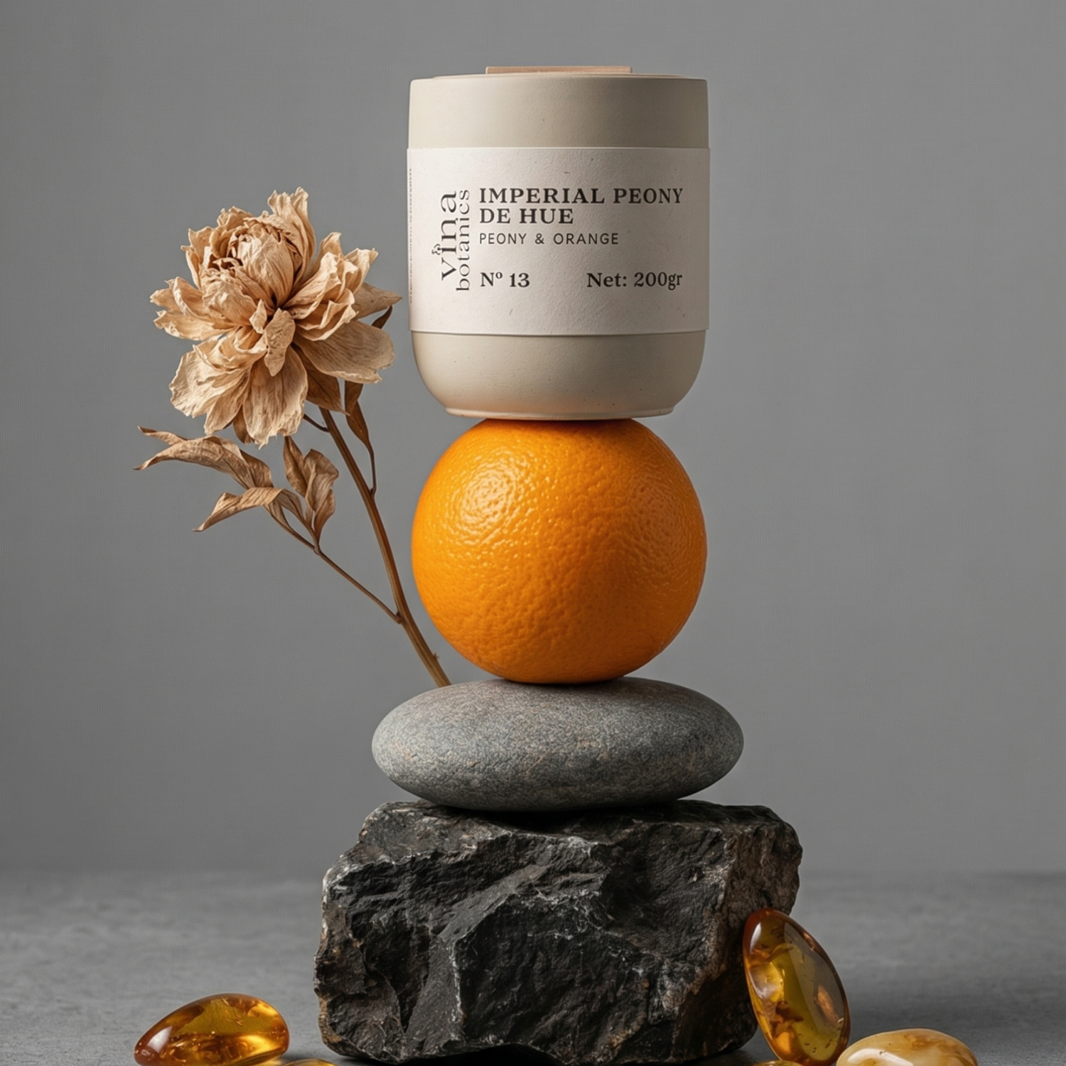 Cosmetic container labeled 'Imperial Peony de Hue' with an orange and dried flower on a gray background