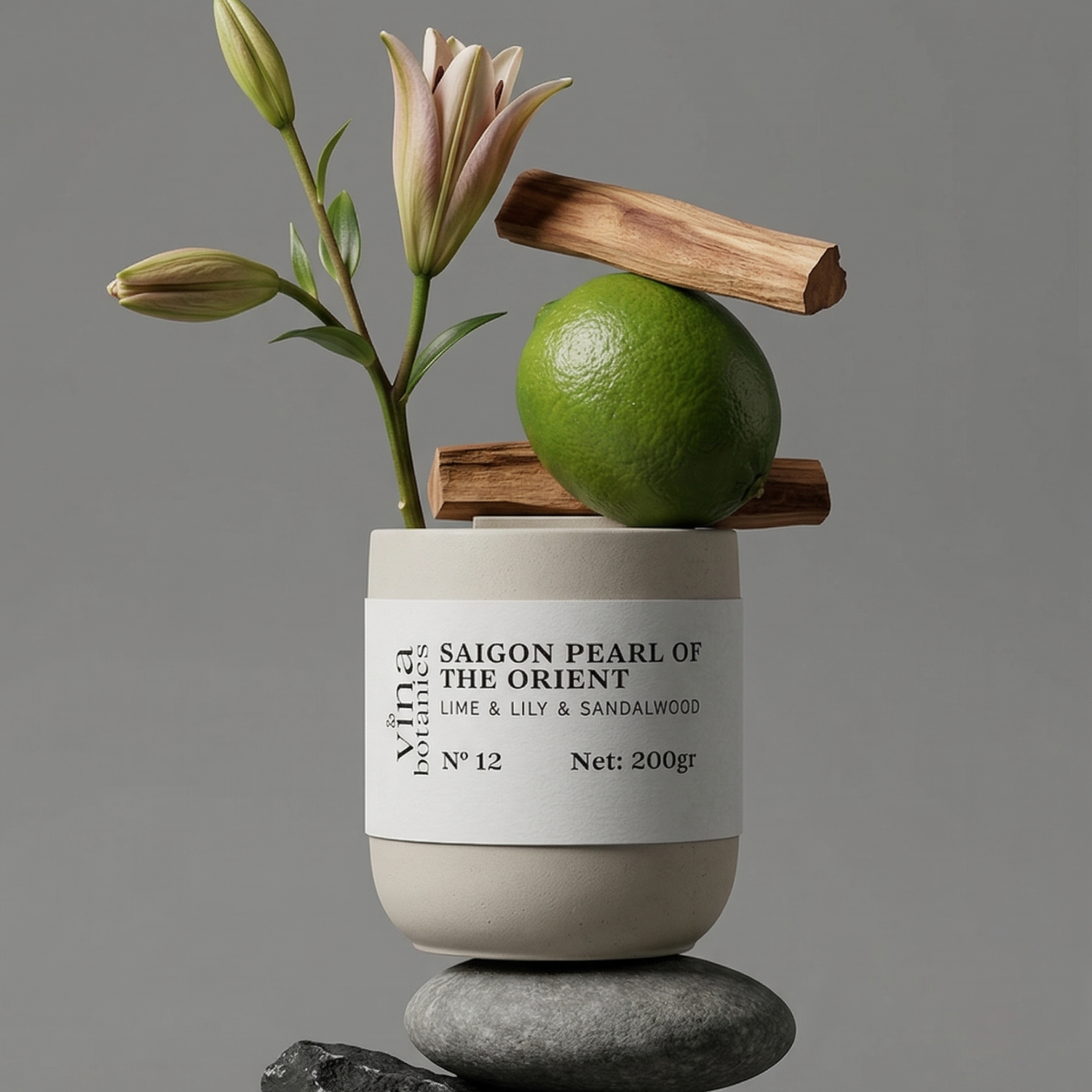 Candle labeled 'Saigon Pearl of the Orient' with a lime and wooden stick on a gray background