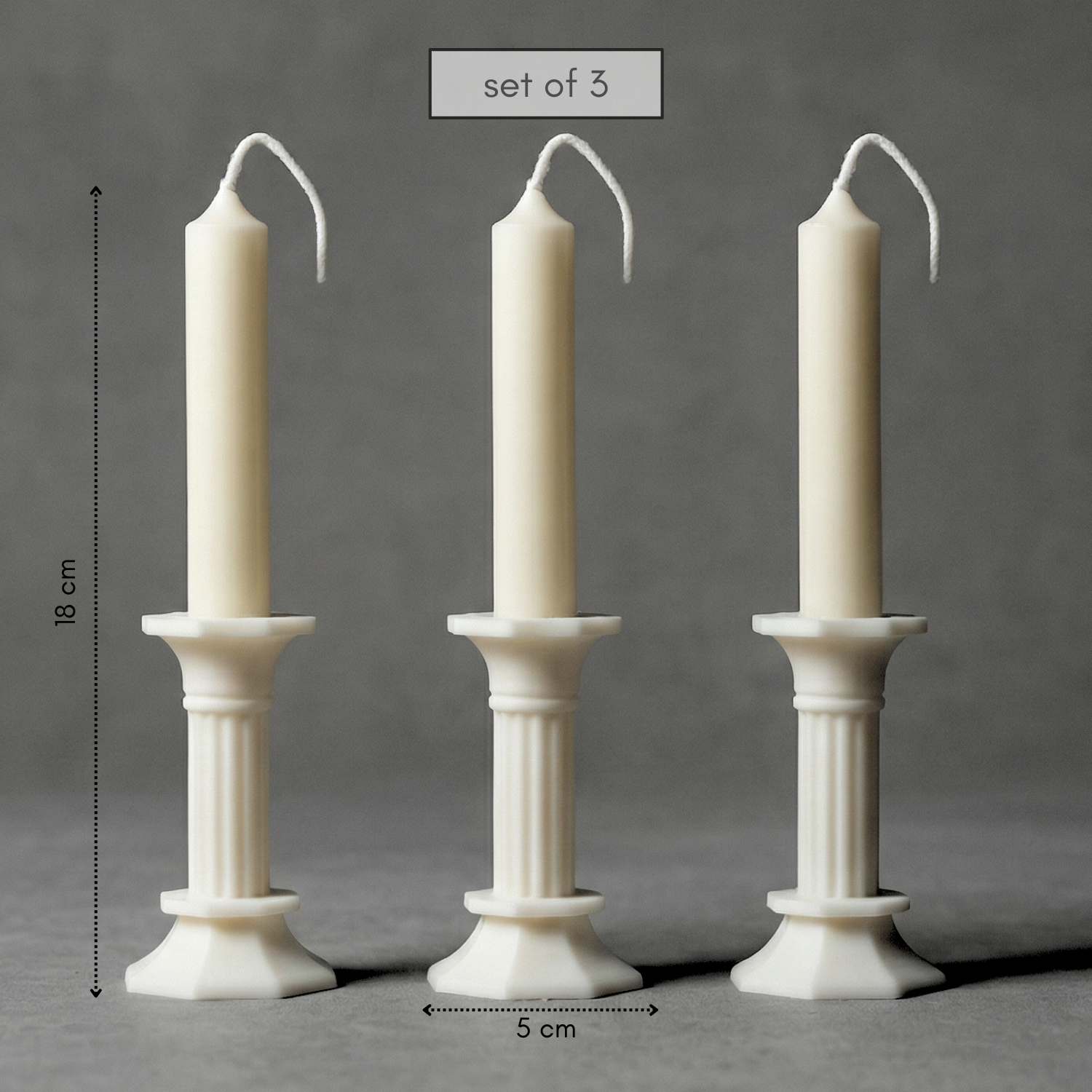 Set of three white candles with candle holders on a gray background, with measurements indicated.