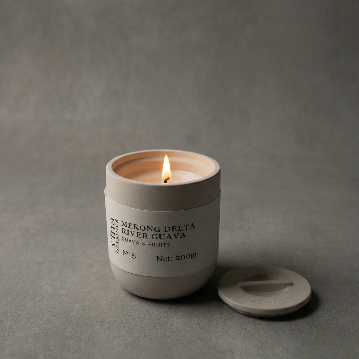 Candle in a beige container with a label on a gray background