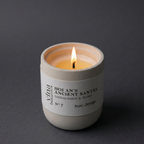 Candle in a white container with a label on a dark background