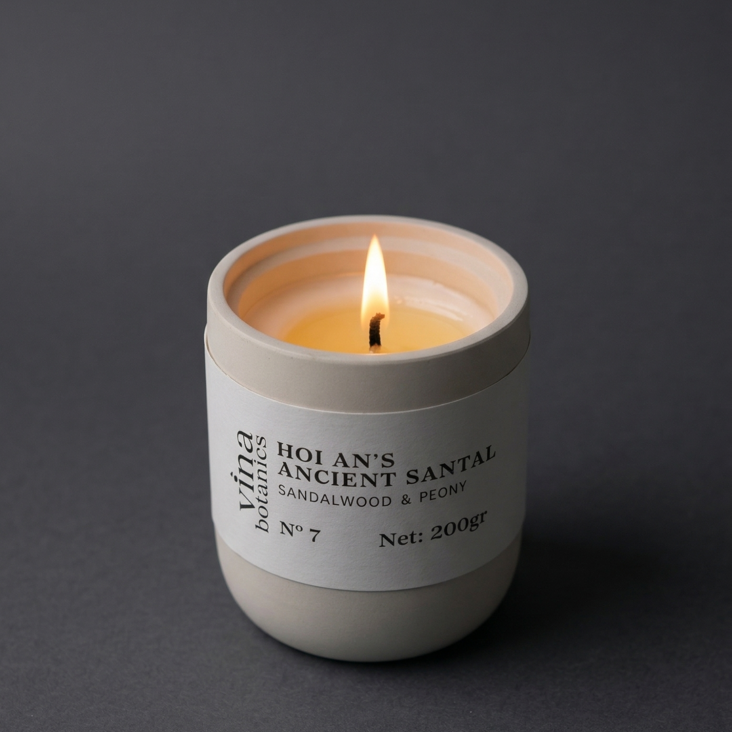 Candle in a white container with a label on a dark background
