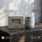 Vina Botanics candle and packaging on a wooden surface with a blurred background